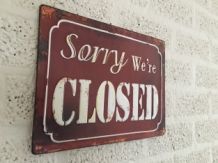 Metalen bord met prachtig geschilderde tekst: Sorry we're closed.